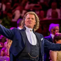 André Rieu w Polsce, dyrygent z wirtuozerską skrzypaczką wita publiczność.