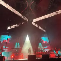 Deftones koncert Polska. Wokalista na scenie, gitarzyści grają, a za nimi ekrany z wizualizacjami.