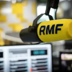 Mikrofon RMF z żółtym wiatrochronem w studiu radiowym. Słuchaj ulubionych stacje radiowe częstotliwości.