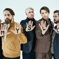 Myslovitz wokalista i zespół pokazują litery na dłoniach: M, Y, S, L, O.