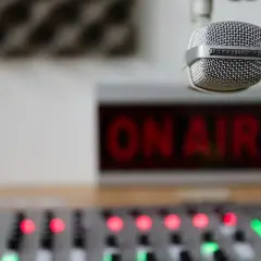Mikrofon gotowy do nadawania, czerwony napis "ON AIR" i konsoleta. Słychać nas na **eska częstotliwość**!