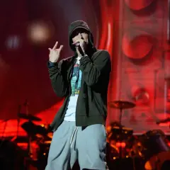 Eminem na scenie, w kapturze i luźnych spodniach, wykonuje swoje kultowe utwory.
