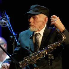 Jan Ptaszyn Wróblewski, legenda polskiego jazzu, z saksofonem w dłoniach, gotowy do gry.