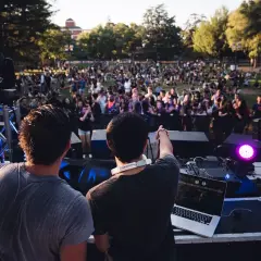 DJ-e tworzą atmosferę deep house na koncercie plenerowym. Tłum bawi się przy muzyce.