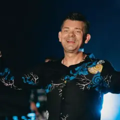 Zenek Martyniuk na scenie, trzyma mikrofon i wskazuje palcem. Szukasz informacji, gdzie najbliższy koncert Zenka Martyniuka?