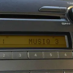 Radio samochodowe z wyświetlaczem RDS, pokazującym "FM 1 MUSIQ 3". Przyciski numeryczne i sterowanie.