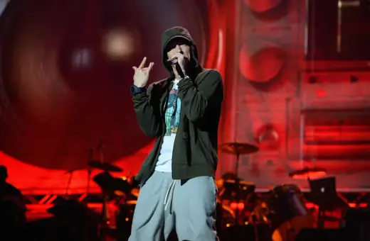 Eminem na scenie, w kapturze i luźnych spodniach, wykonuje swoje kultowe utwory.