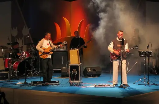 Zespół gra na scenie. Wokalista śpiewa, gitarzyści grają. Raz, dwa, trzy utwory i publiczność szaleje.
