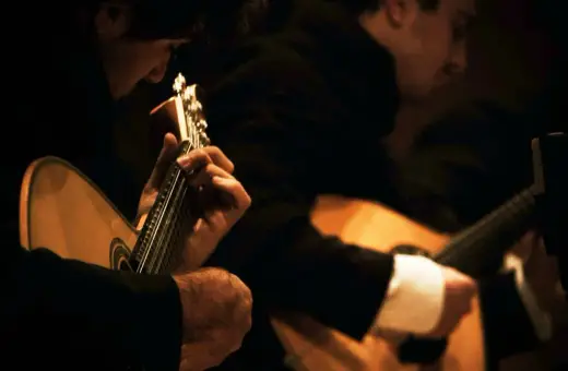 Muzycy grający na gitarach portugalskich, tworząc melancholijne **fado**.