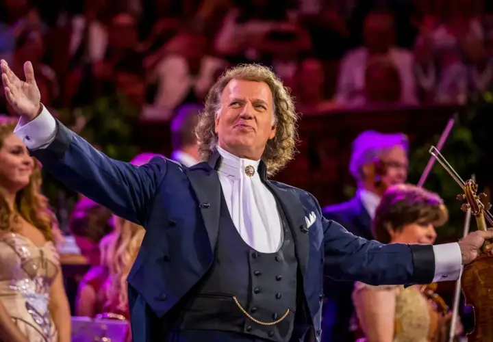 André Rieu w Polsce, dyrygent z wirtuozerską skrzypaczką wita publiczność.