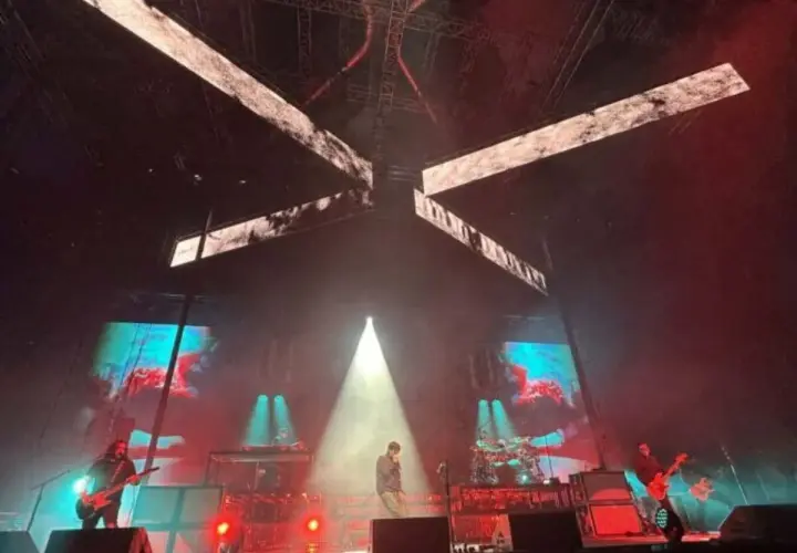 Deftones koncert Polska. Wokalista na scenie, gitarzyści grają, a za nimi ekrany z wizualizacjami.