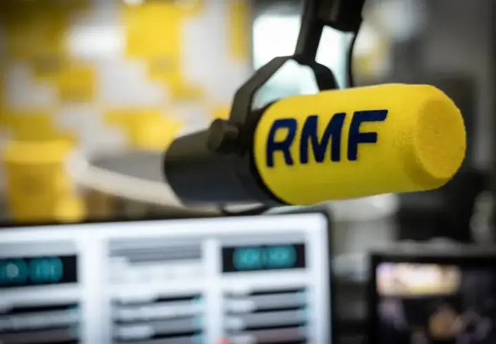 Mikrofon RMF z żółtym wiatrochronem w studiu radiowym. Słuchaj ulubionych stacje radiowe częstotliwości.