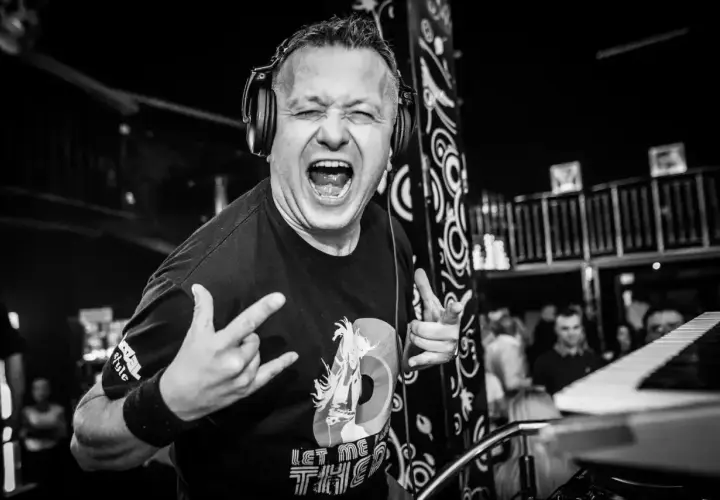 DJ Hazel w akcji, z mikrofonem i słuchawkami, krzyczy do publiczności. Sprawdź jego dj hazel cennik na imprezy!