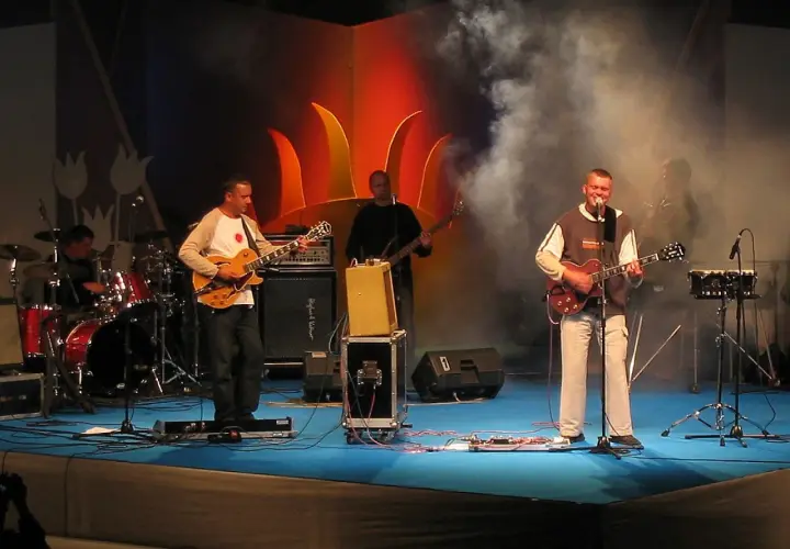 Zespół gra na scenie. Wokalista śpiewa, gitarzyści grają. Raz, dwa, trzy utwory i publiczność szaleje.