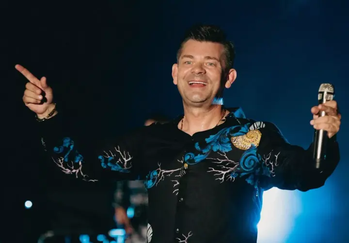 Zenek Martyniuk na scenie, trzyma mikrofon i wskazuje palcem. Szukasz informacji, gdzie najbliższy koncert Zenka Martyniuka?