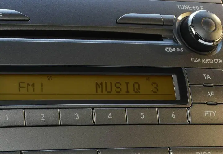 Radio samochodowe z wyświetlaczem RDS, pokazującym "FM 1 MUSIQ 3". Przyciski numeryczne i sterowanie.