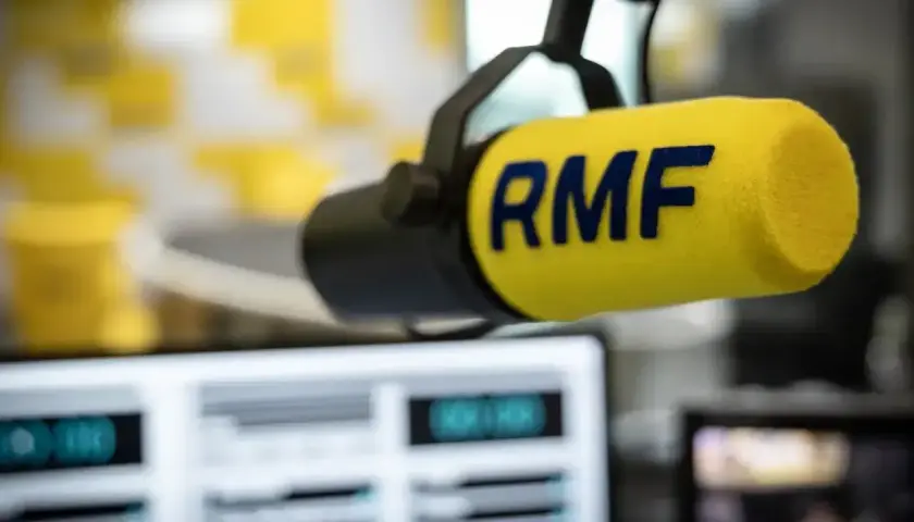 Mikrofon RMF z żółtym wiatrochronem w studiu radiowym. Słuchaj ulubionych stacje radiowe częstotliwości.