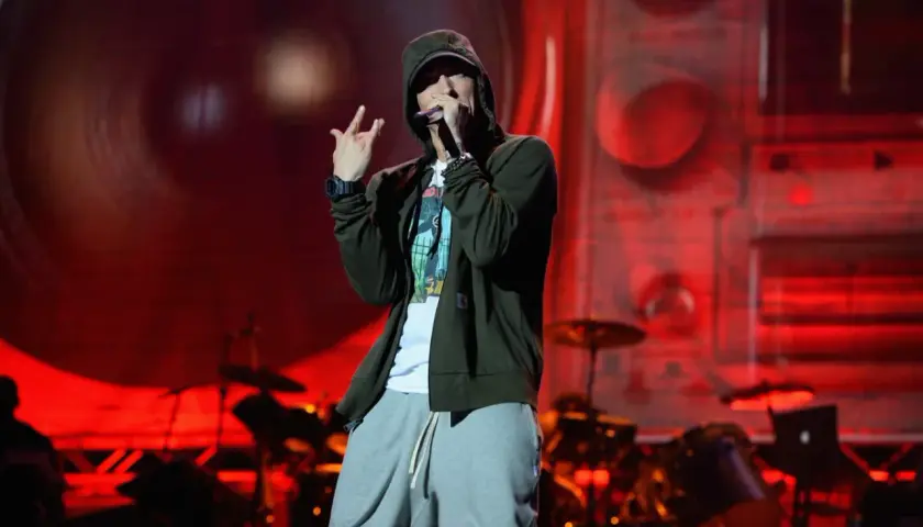 Eminem na scenie, w kapturze i luźnych spodniach, wykonuje swoje kultowe utwory.