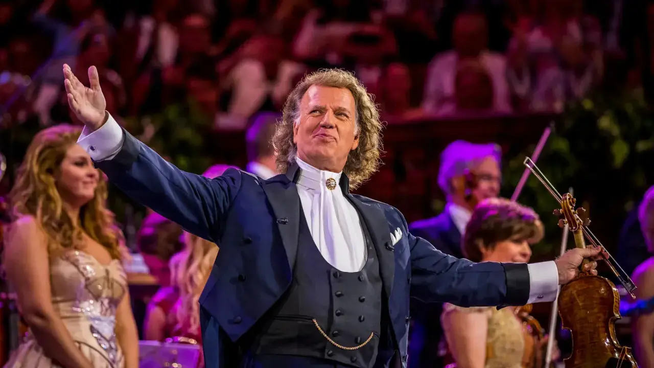 André Rieu w Polsce, dyrygent z wirtuozerską skrzypaczką wita publiczność.
