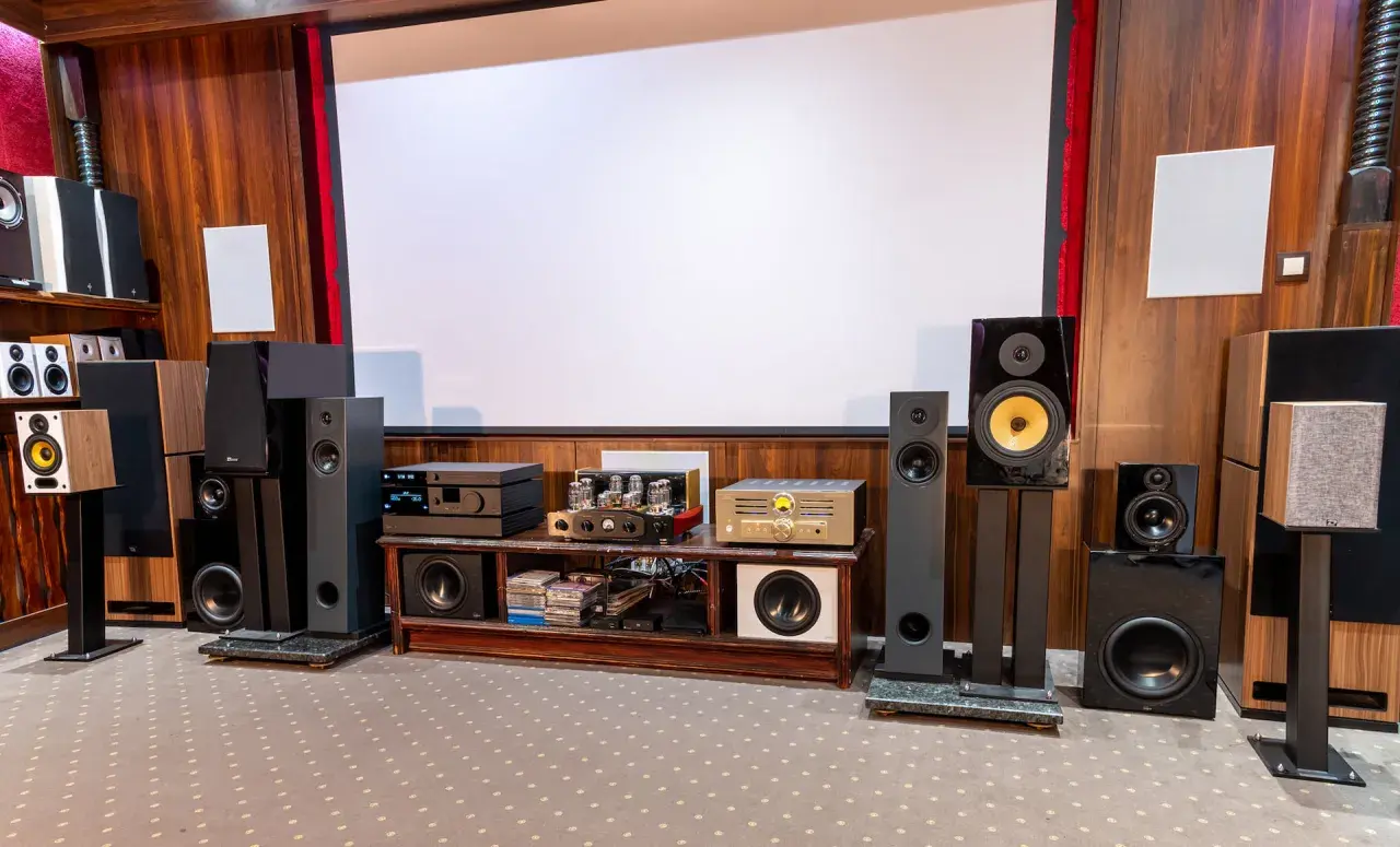 Pokój kinowy z wieloma głośnikami i sprzętem audio, idealny dla każdego audiofila.