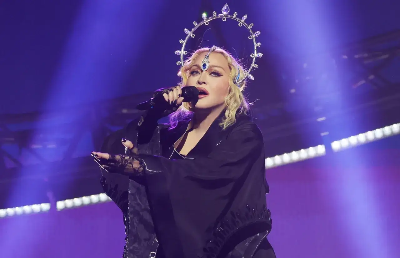 Madonna w koronie z kryształów śpiewa na scenie, wykonując swoje legendarne utwory.