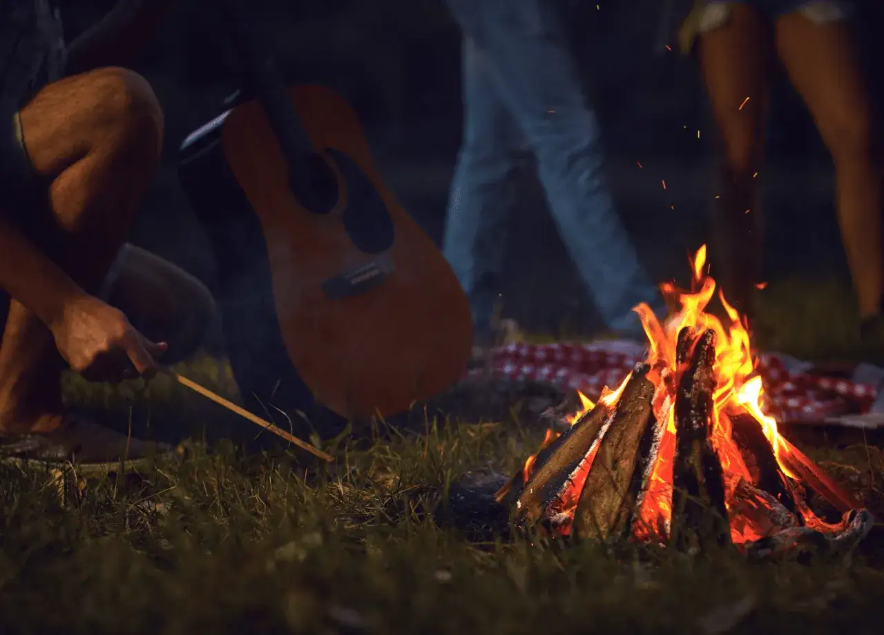 Ognisko, gitara i przyjaciele – idealne warunki na wieczór pełen piosenek do śpiewania.