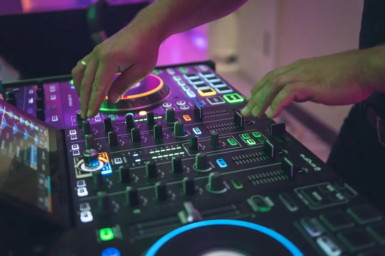 DJ za konsolą grający na imprezie