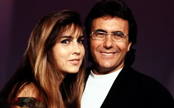 Al Bano i Romina Power, uśmiechnięci, pozują do zdjęcia. Ona ma długie, brązowe włosy, on okulary.
